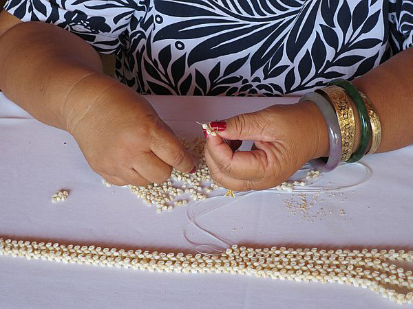 [Niʻihau woman making shell lei] Photo by Hiart.